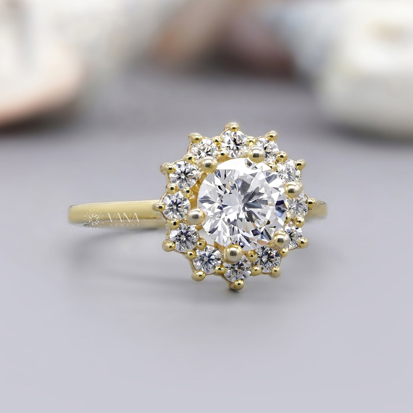 Gold ring with a large central diamond and smaller diamonds around on a light background