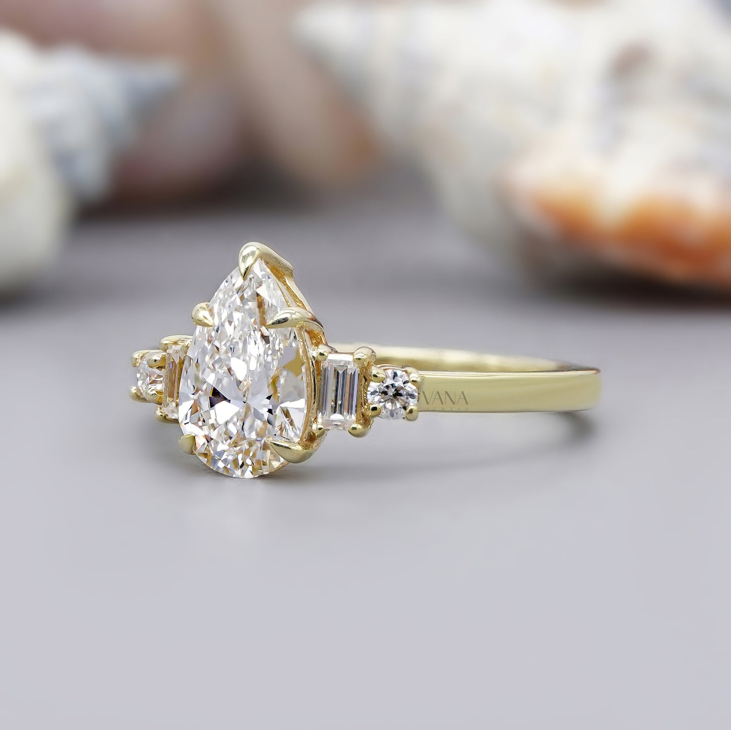 Pear cut moissanite engagement ring with baguette and round side stones