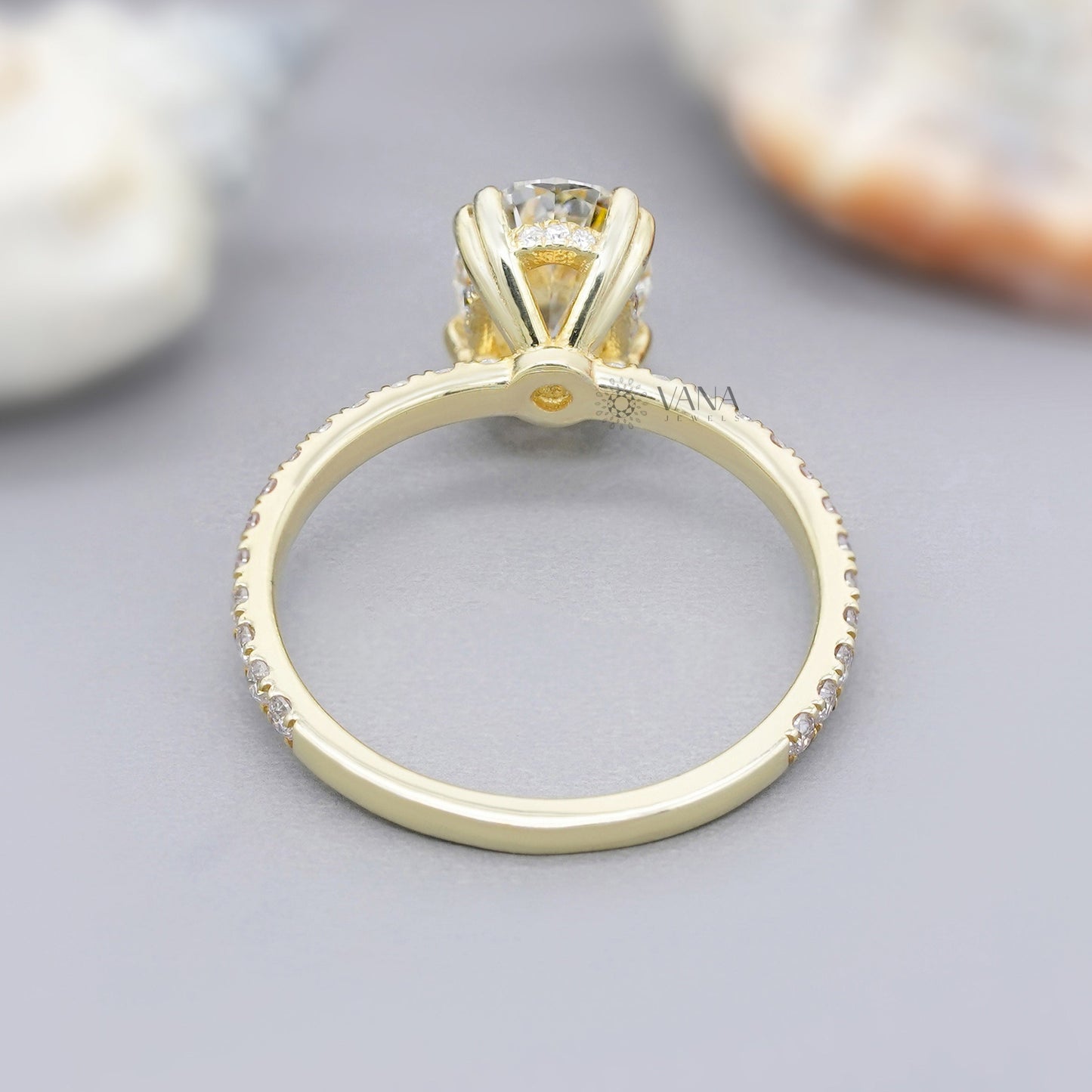 Double claw prong oval moissanite engagement ring in 14K yellow gold with hidden halo