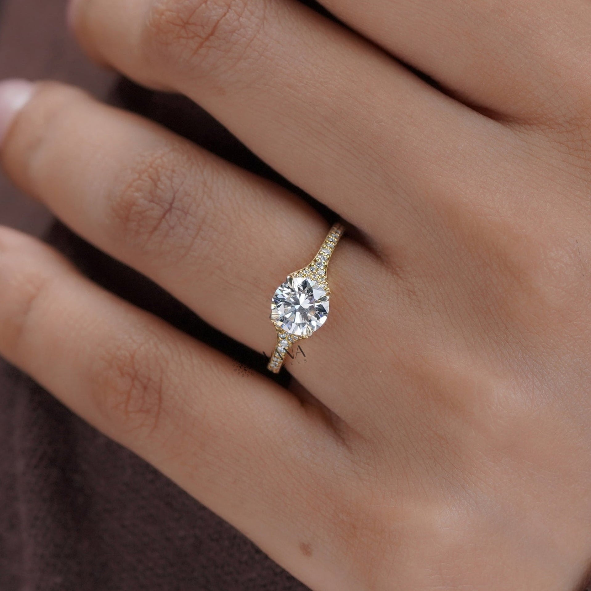 Hand model wearing yellow gold round moissanite engagement ring