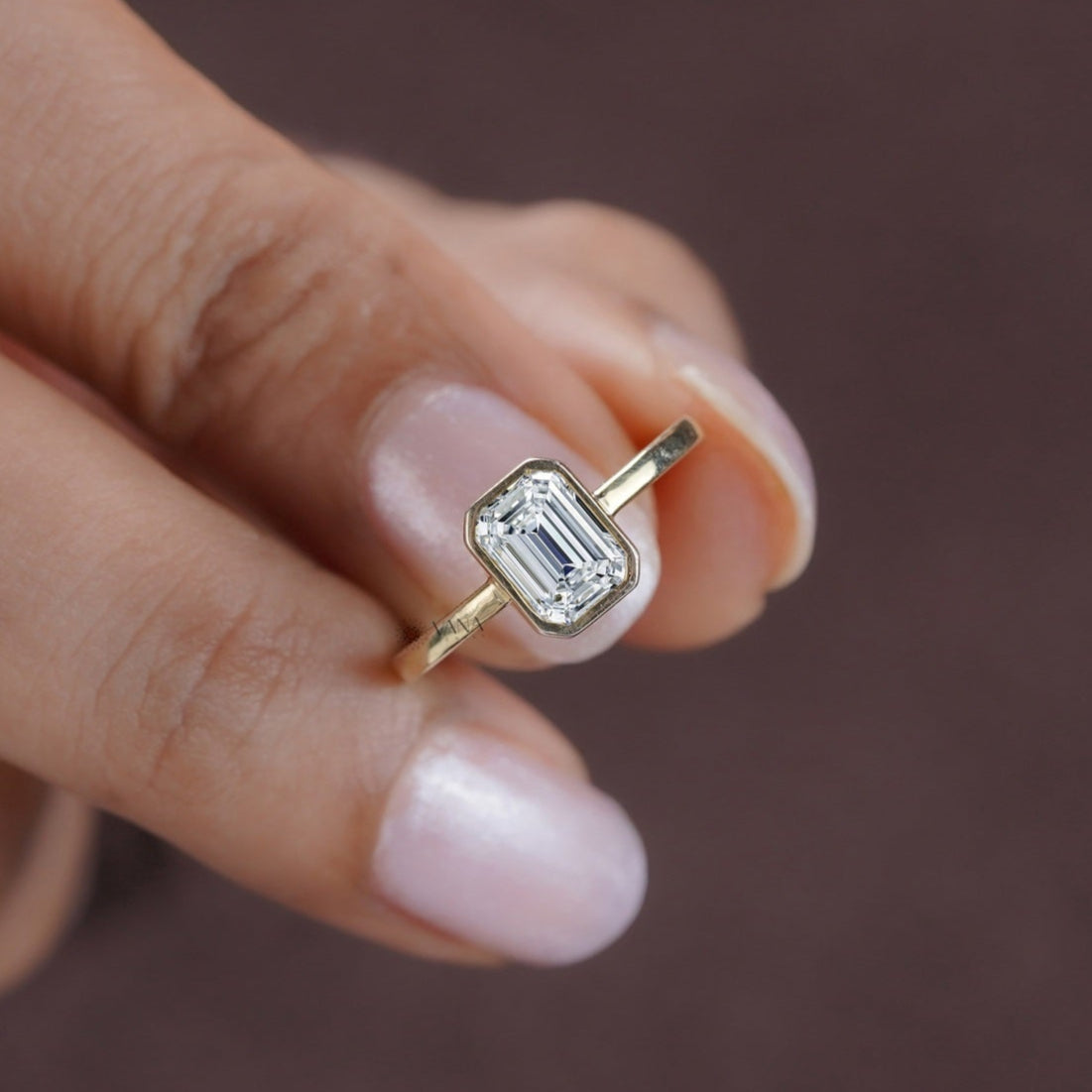 Handmade engagement ring with bezel set emerald cut moissanite