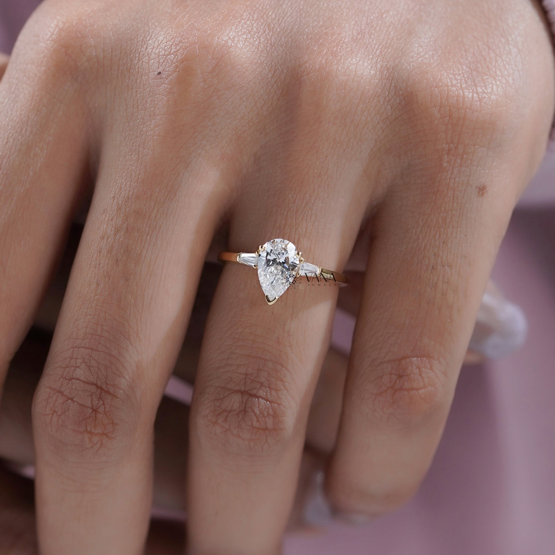 Three stone engagement ring with pear and baguette diamonds

