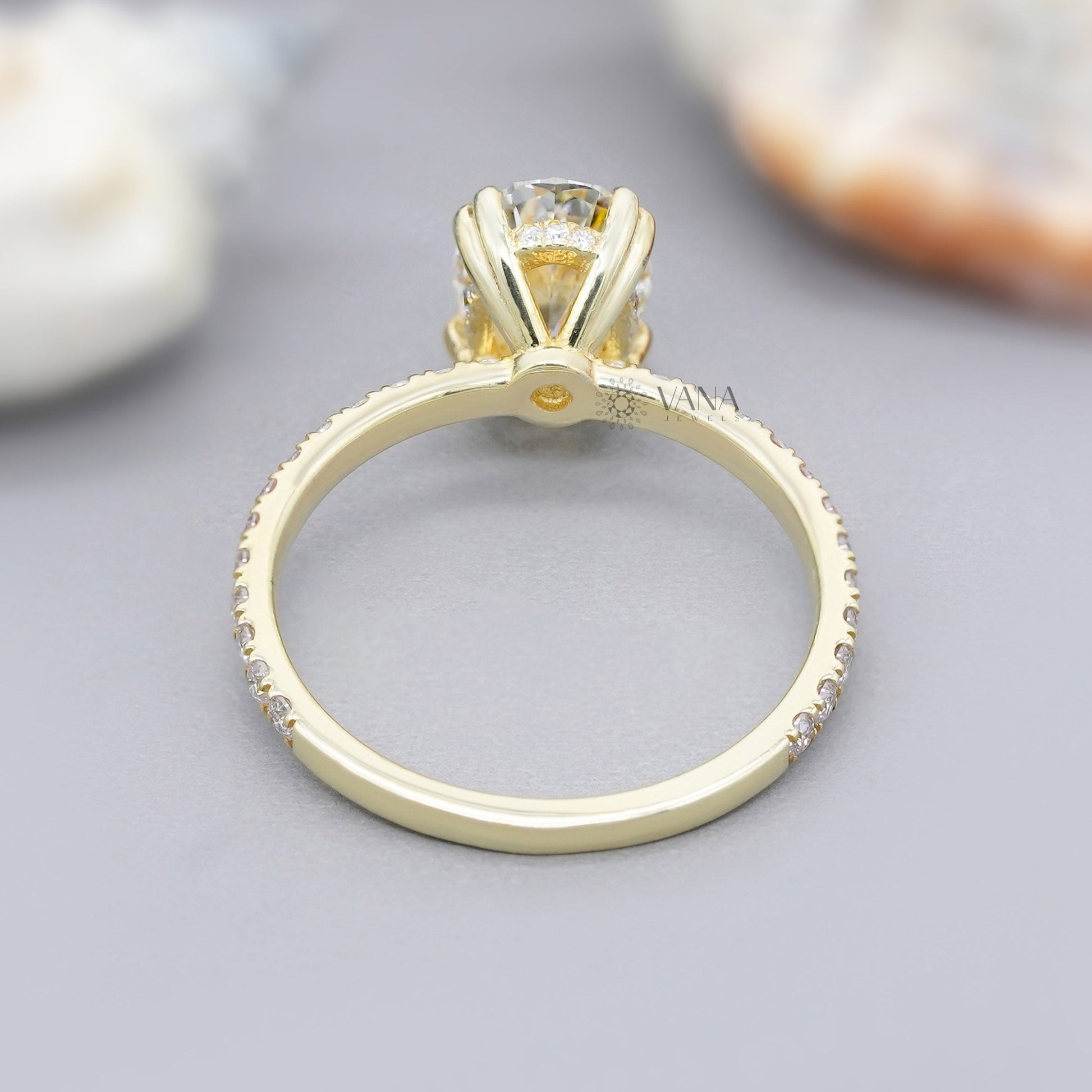 Double claw prong oval moissanite engagement ring in 14K yellow gold with hidden halo